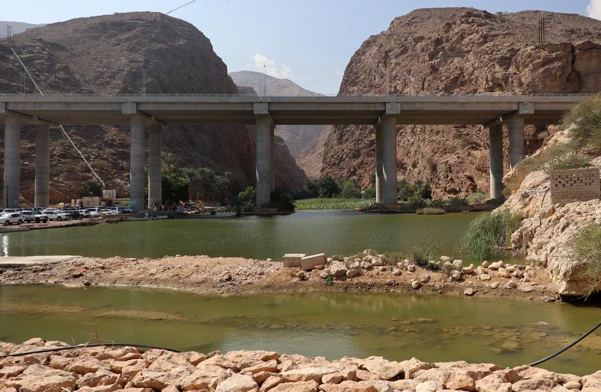 The highway bridge over the mouth of Wadi Shab with the car park and the water where the boats cross